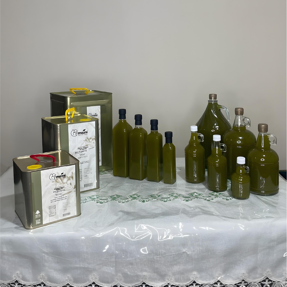 title="Retail: Handmade Lebanese olive oil in bottles and tins" alt="Olive oil bottles and tins in various sizes on a table"
